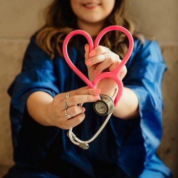 a nurse with a stethoscope in the shape of a heart 